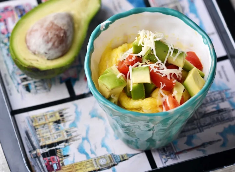 breakfast with avocado and scrambled eggs on vegetables with grated feta cheese for a healthy start to the day