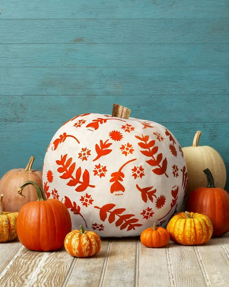 Find some leaf and flower stencils, glue them to your pumpkin and add craft paint