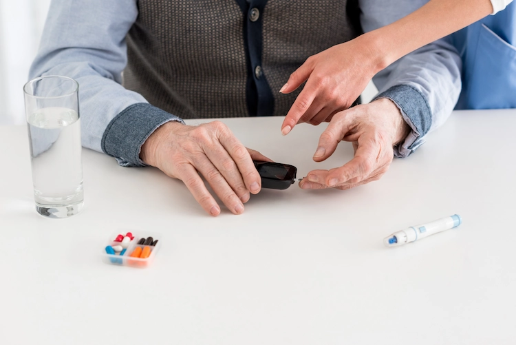 senior caregiver checking blood sugar to measure blood sugar levels at home